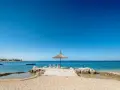 Słoneczny dzień na plaży w Simuni camping. Leżaki pod parasolem, dmuchany plac zabaw w wodzie i błękitne morze.
