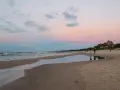 Zachód słońca nad morzem w kurorcie niedaleko Lęborka. Piękne, pastelowe niebo odbija się w wodzie na plaży.