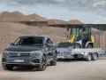 Szary Volkswagen Touareg z przyczepą, na której stoi ładowarka. To auto ma 3,5 tony na haku, gotowe do pracy.