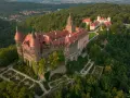Zamek Książ otoczony zielenią, z pięknymi ogrodami i widokiem na okoliczne góry. To wspaniałe miejsce, by odkrywać atrakcje Gór Sowich.