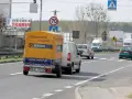 Samochód z żółtą przyczepką Statoil jedzie drogą. Znak ograniczenia do 70 km/h sugeruje, ile można jechać z przyczepką w tym miejscu.