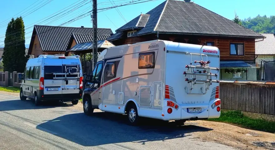 Dwa kampery zaparkowane na drodze w Rumunii, gotowe na przygodę.