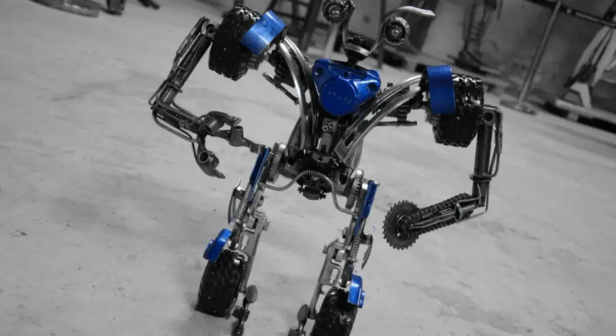 Metalowy robot z niebieskimi akcentami, wyglądający jakby właśnie opuścił fabrykę robotów w Mosznej.