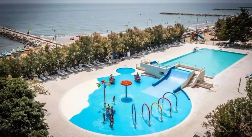 Rodzinna zabawa w wodnym świecie przy plaży w San Francesco Caorle: baseny, zjeżdżalnie i brodziki dla dzieci.