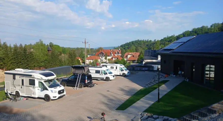 Kampery i samochody kempingowe zaparkowane na placu, gotowe na przygodę w Kudowie-Zdroju.
