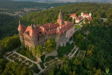 Zamek Książ otoczony zielenią, z pięknymi ogrodami i widokiem na okoliczne góry. To wspaniałe miejsce, by odkrywać atrakcje Gór Sowich.